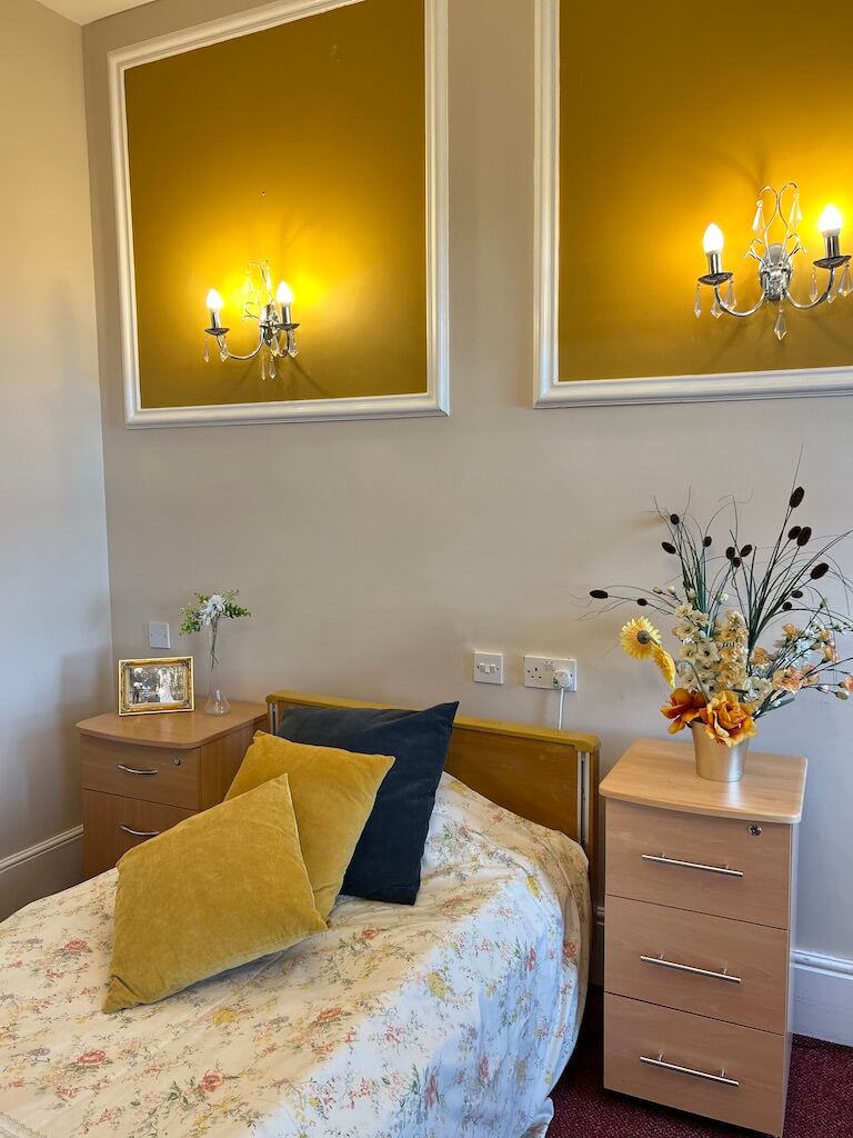 Bedroom bed with yellow and blue cushions